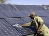 Khalahari Plains Camp, camp employee in hat washing off solar pannels, checkerboard solar pannels, Botswana safari, Africa