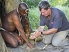 Khalahari Plains Camp, native dressed in traditional  oufit teaching guest how to light a fire by twisting stick to create friciton, fire starting