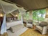 Jacana Camp, spacious bedroom with accompanying reading chairs, camopied bed area, wonderful views of Botswana wilderness and Okavango Delta, green 
