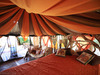 Elephant Watch Camp, beautifully designed bedroom with orange and brown canopy expanding throughout the ceiling of the room in Kenya, Africa safaris