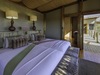 Khalahari Plains Camp, inviting bedroom, two large beds with personal lighting, easy access walkway with protective railing to rest of camp, Botswana