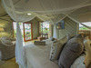 Jacana Camp, luxurious bedroom with large bed, overhanging canopy for insect protection, canvas walled room, sliding glass door, squishy pillows, 